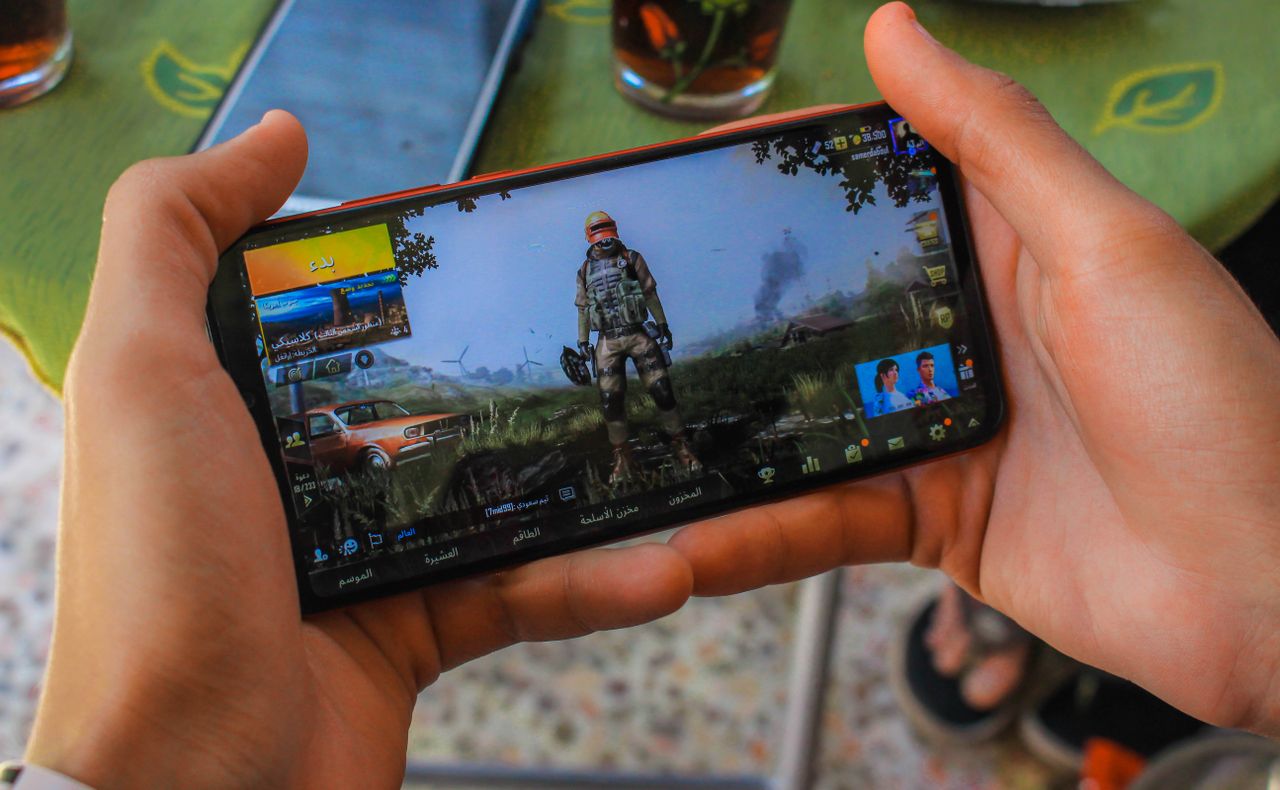 about-bg-img From above crop anonymous male playing captivating video game on contemporary mobile phone near table on terrace